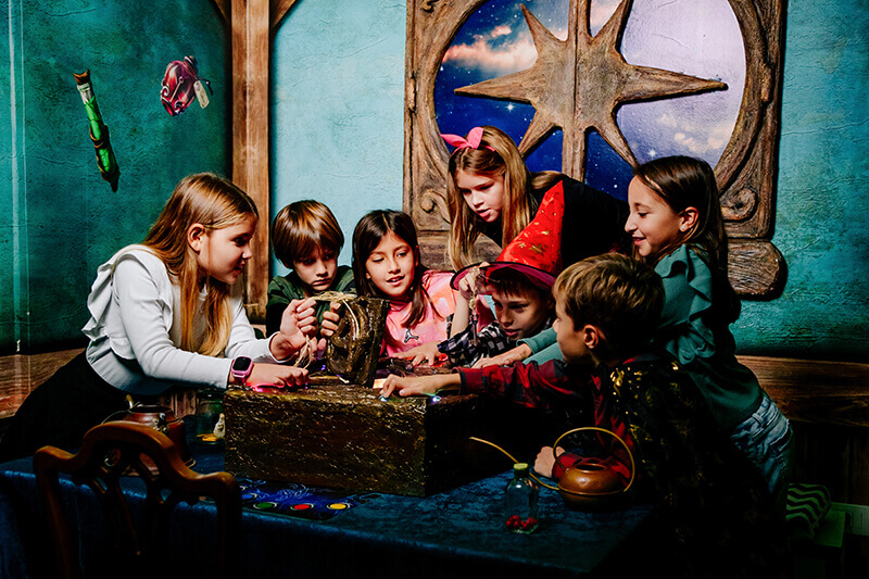 Children solving a themed escape-room challenge together at Cluville, Arizona Boardwalk